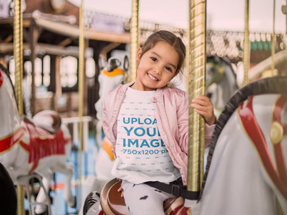 T-Shirt Mockup of a Smiling Little Girl on a Carousel Horse