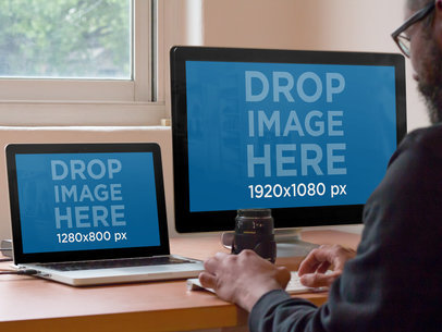 Mockup of a Designer Using a Macbook Pro and an iMac at Work