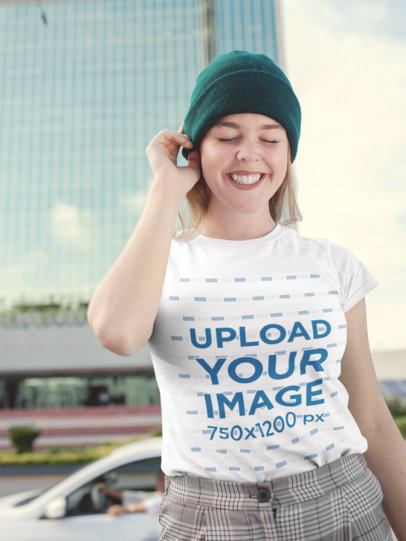 Round Neck Tee Mockup of a Smiling Woman Wearing a Beanie on the Street