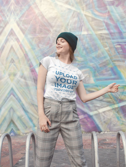 T-Shirt Mockup of a Woman Smiling in Front of Street Art