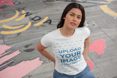 Mockup of a Woman Wearing a T-Shirt Standing on Street Art