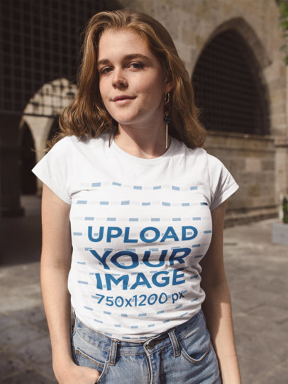 T-Shirt Mockup Showing a Woman Wearing Jeans at a Church Courtyard