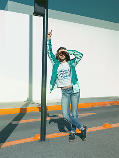 Mockup of a Woman Wearing a T-Shirt Leaning on a Street Pole 18476