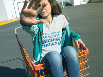 T-Shirt Mockup of a Woman in a Shopping Cart Blocking the Camera from Her Face