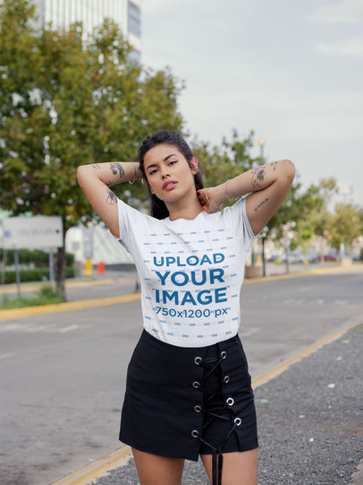 T-Shirt Mockup of a Woman with Tattoos Wearing a Dark Skirt on the Street