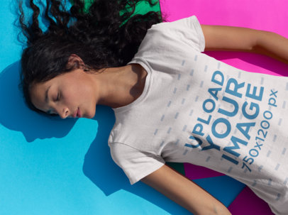 Tee Mockup of a Woman Lying in the Sun Over Colorful Cardboard 18431