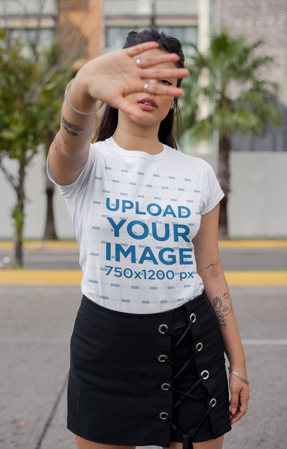 T-Shirt Mockup of a Woman Blocking the Camera on the Street