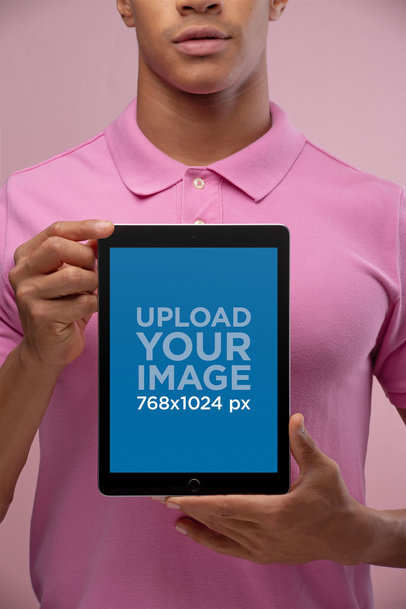 Mockup of a Man Holding an iPad Wearing a Pink Polo Shirt