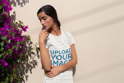 Mockup of a Girl Wearing a Round Neck Tshirt Looking at Dark Pink Flowers 18437