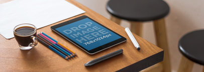 Tablet Mockup of a Black iPad Mini Over a Designer Studio