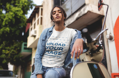 Mockup of a Woman Wearing a T-Shirt Leaning Over her Motorcycle