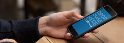 Man at a Bar Holding Black iPhone 6 Mockup