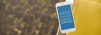 iPhone 6 Mockup Template Next to a Yellow Chair at a Terrace