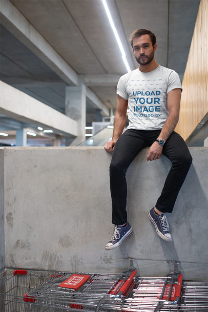 T-Shirt Mockup of a Man Sitting on a Cement Wall