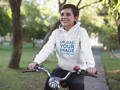 Hoodie Mockup Featuring a Happy Woman Riding a Bicycle in the Park