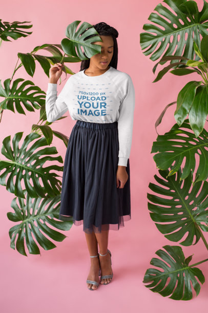 Mockup of a Girl Wearing a Crewneck Sweater in a Pink Studio with Plants 18398