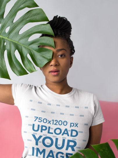T-Shirt Mockup of a Woman Holding a Large Leaf Up to Her Face