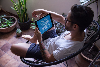 Landscape iPad Mockup Featuring a Man Sitting Nearby Plants 22818