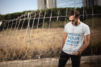 T-Shirt Mockup of a Man with Round Sunglasses Outdoors