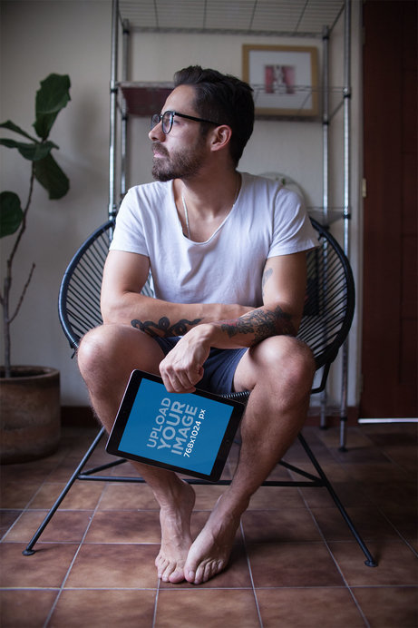 iPad Mockup Featuring a Man sitting on an Acapulco Chair