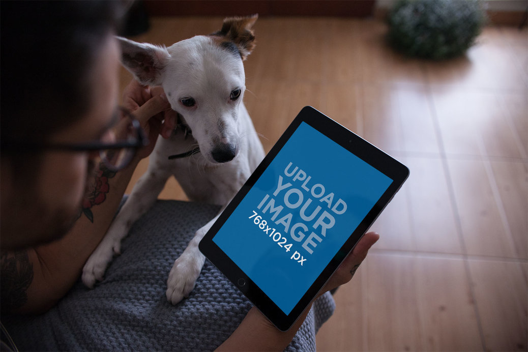 iPad Mockup Featuring a Man Petting His Dog at Home