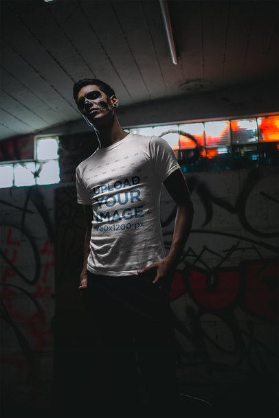 T-Shirt Mockup Featuring a Man with Skull Makeup in a Basement 23036