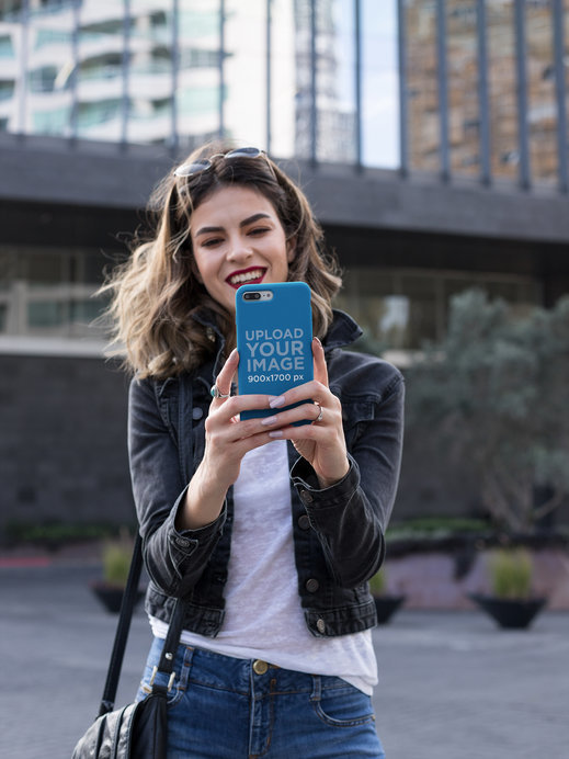 Mockup of a Phone Case Held By a Woman Taking a Photo