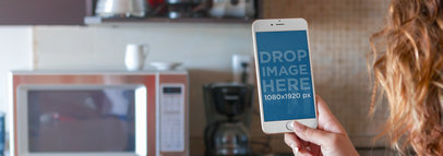 Mockup of a Woman at the Kitchen Using an iPhone 6 