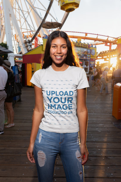 Mockup of a Smiling Woman Wearing a Tshirt at an Amusement Park