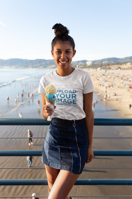 T-Shirt Mockup of a Happy Woman with an Ice Cream at a Beach Pier