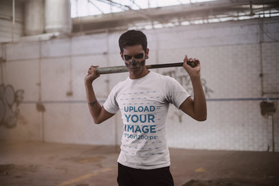 Halloween T-Shirt Mockup Featuring a Man with Skull Make-Up Holding a Baseball Bat Against his Back 23022