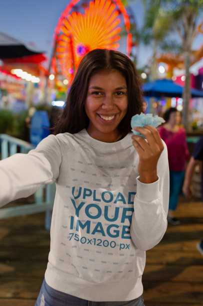 Mockup of a Woman Wearing a Sweatshirt in a Carnival Setting