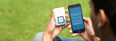 Young Man Scanning a QR Code With an iPhone at the Garden a4083