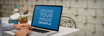 Laptop Mockup of a Man Using a Macbook at a Cafe