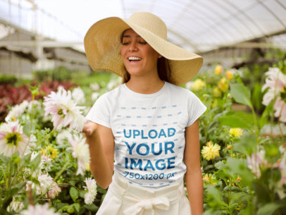 Mockup of a Happy Woman Wearing a Tshirt and a Sun Hat in a Greenhouse
