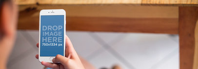 iPhone Mockup Featuring a Woman Using an iPhone 6 at Home