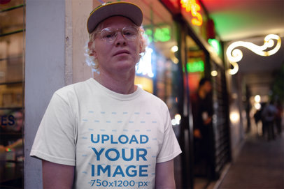 Round Neck Tee Mockup of a Man Outside a Store with Neon Signs at Night