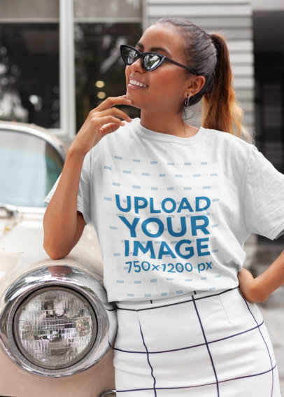 Unisex T-Shirt Mockup Featuring a Trendy Woman Leaning on a Classic Car
