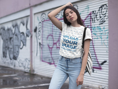 Mockup of a Serious Woman Wearing a Tshirt Standing Against Urban Art