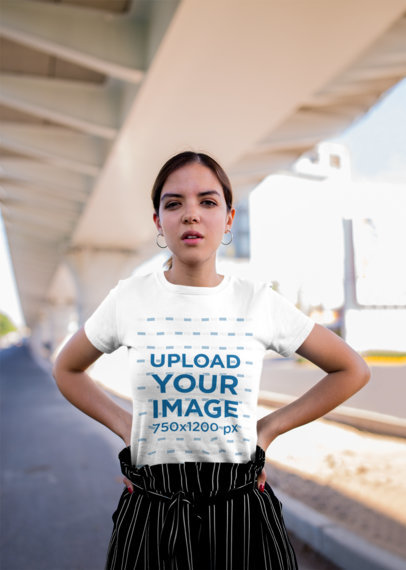 Mockup of a Woman Wearing a Tee and Posing Under a Bridge