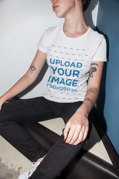 Unisex Round Neck Tee Mockup Featuring a Cropped Face Woman Sitting Against a Corner