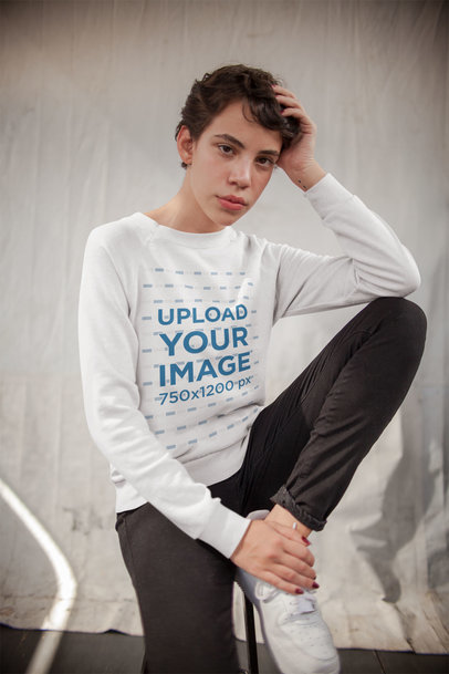 Mockup of a Pretty Woman Wearing a Sweater Sitting on a Stool