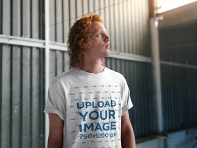 T-Shirt Mockup Featuring a Red-Haired Man Looking up at the Ceiling