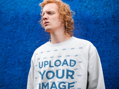 Crewneck Sweatshirt Mockup of a Red-Haired Man Against a Blue Wall