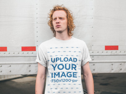 Tee Mockup of a Man with Red Hair Leaning on a Reefer Trailer