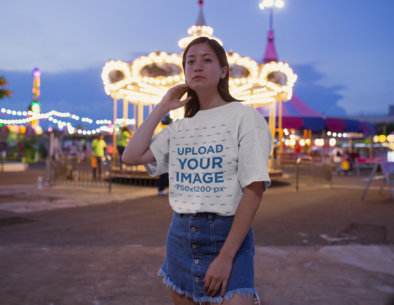 Baggy Tee Mockup of a Woman Standing Against a Carousel