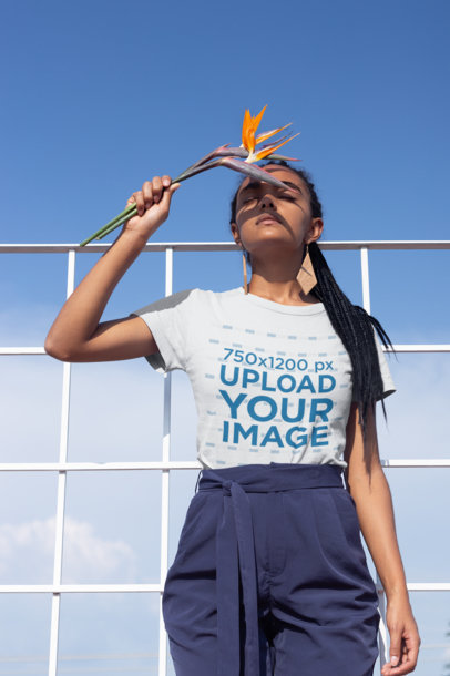 T-Shirt Mockup of a Girl with Braids Holding a Bird-of-Paradise Flower 21806