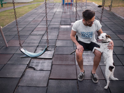 Tee Mockup Featuring a Man Petting His Dog While Sitting on a Swing