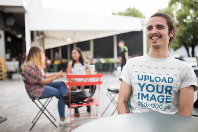 Mockup of Smiling Man in an Outdoor Cafeteria Wearing a T-Shirt