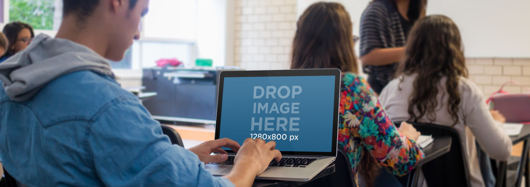 Placeit - Young Male Student Using a Macbook Pro During Class Mockup